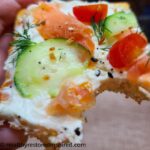 Low carb crust topped with dairy-free cream cheese, cucumbers and smoked salmon